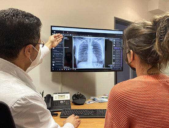 Mahmoud Ismail erklärt seiner Patientin Kirstin was auf den Röntgenbildern zu erkennen ist.