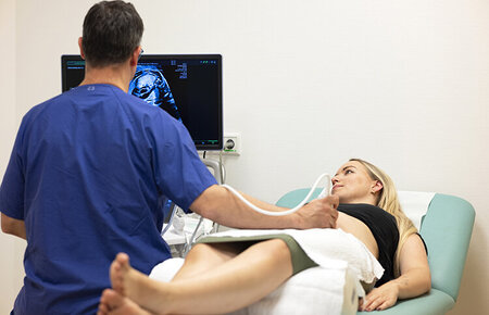 Arzt untersucht eine Schwangere mit einem Ultraschallgerät