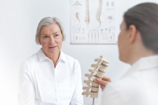 Orthopädin berät eine Patientin zu Wirbelsäulenerkrankungen