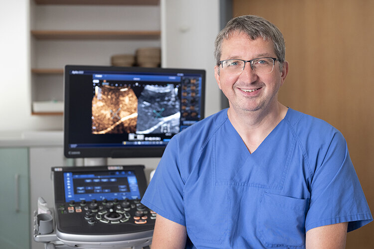 Arzt sitzt vor einem Ultraschallgerät