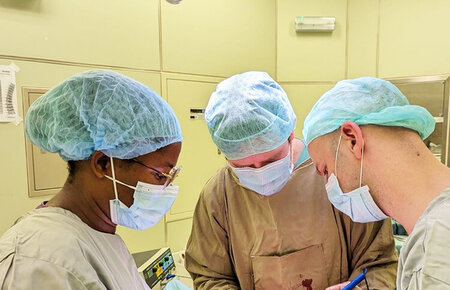 Operation: Dr. Schmidt und Dr. Schreiber führen gemeinsam mit einer Kollegin aus São Tomé einen chirurgischen Eingriff durch.