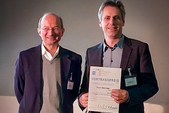 Herr Heinemann (rechts) erhält die Auszeichnung zum besten Vortrag in der Reihe "Cornea"