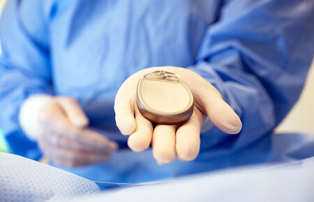Ärztin hält einen Defibrillator in Ihrer Hand