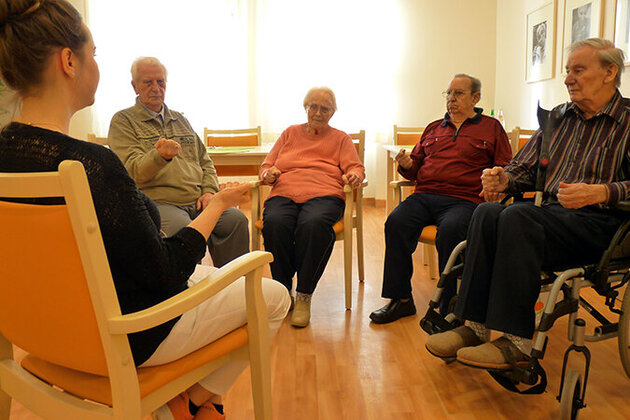 Psychologin mit 4 Patientinnen und Patienten bei der Entspannungstherapie